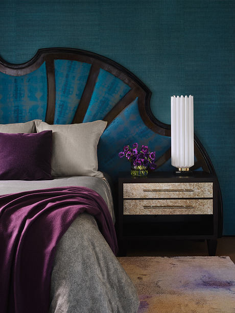 Elegant bedroom with a vintage bed, modern lamp, and vibrant textiles.