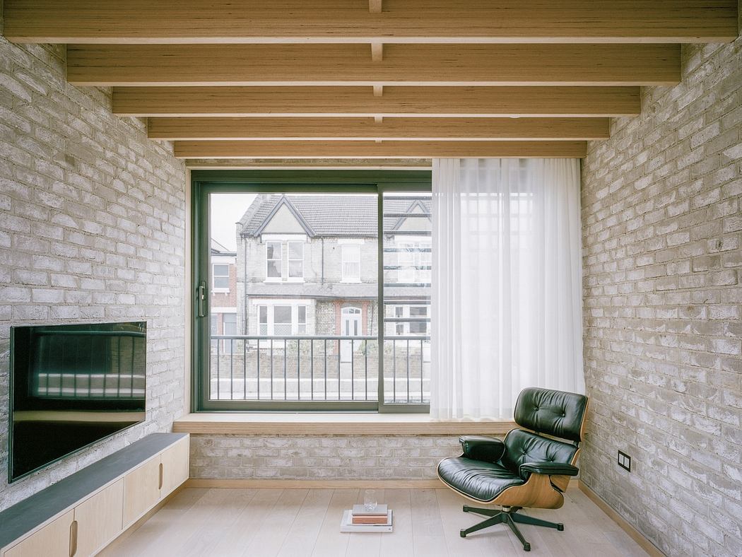 Minimalist interior with exposed brick walls, wooden ceiling, and iconic lounge chair.