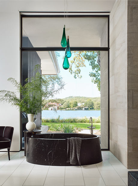 Modern bathroom with a large window overlooking a lake.