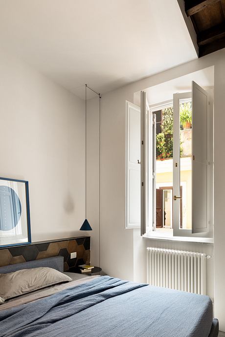 Minimalist bedroom with open window letting in natural light.