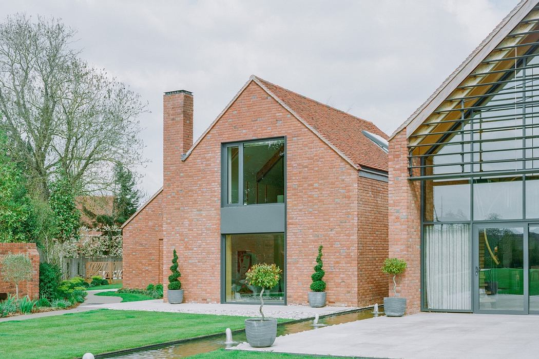 Modern brick house with large glass windows and manicured lawn.