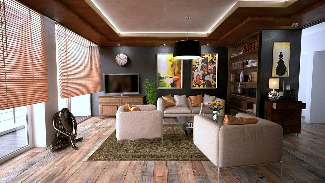 Modern living room with beige furniture, a TV, and wooden floors.