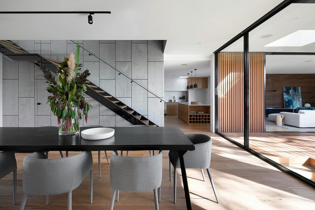 Modern dining room with staircase and open-plan living area.