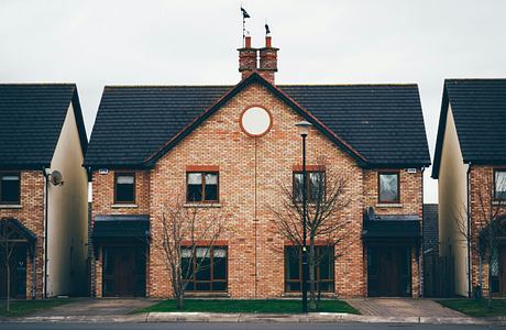 Symmetrical brick houses with circular window detail.