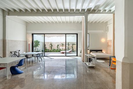 Modern open-plan living space with sleek furniture and large windows.