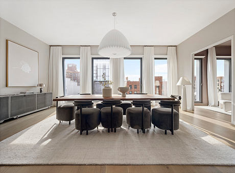 Elegant dining room with floor-to-ceiling windows, plush velvet chairs, and a modern chandelier.