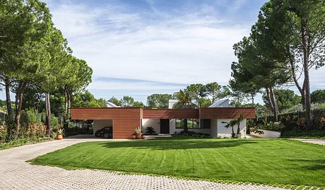 A modern single-story home with a prominent wooden awning and lush landscaping.