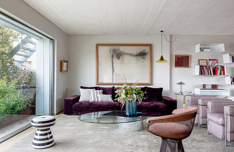 Contemporary living room with elegant purple sofa and minimalist decor.