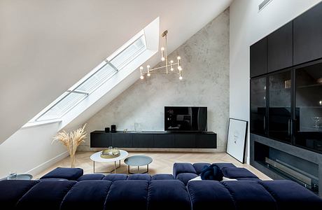 Minimalist attic living space with skylight and plush sofa.