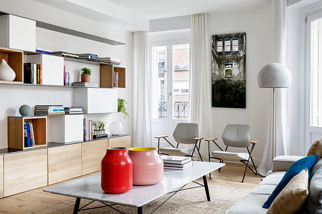 Bright, modern living room with sleek furniture and bookshelf.