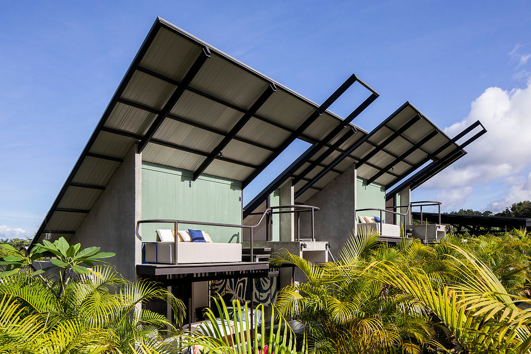 Modern tropical homes with sloping roofs and balconies amidst lush greenery.