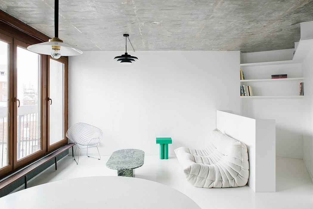 Minimalist living room with concrete ceiling, white walls, modern furniture, and shelving.