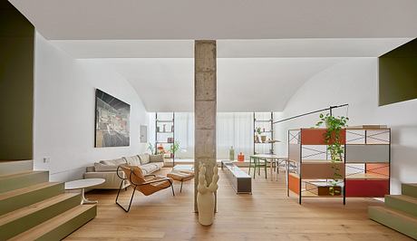 Minimalist interior with exposed column, arched niches, and light wood tones