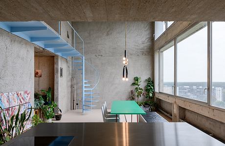 Modern interior with concrete walls, a spiral staircase, and minimalist furniture.