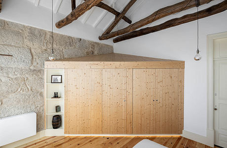 Modern room with wooden cube structure, exposed beams, and stone wall.