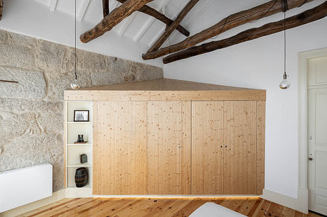 Modern room with wooden cube structure, exposed beams, and stone wall.