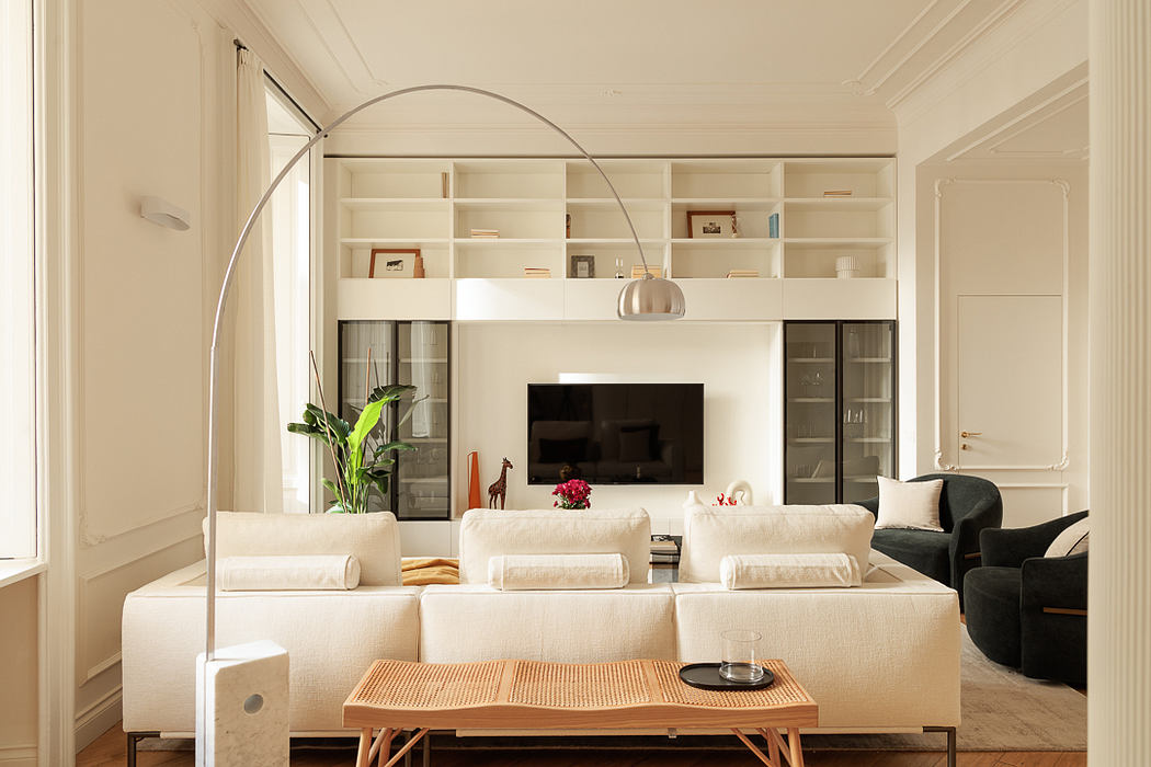 Elegant living room with white sofa, arched lamp, and built-in shelves