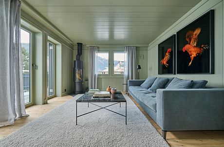 Contemporary living room with wood stove, plush sofa, and vibrant art.