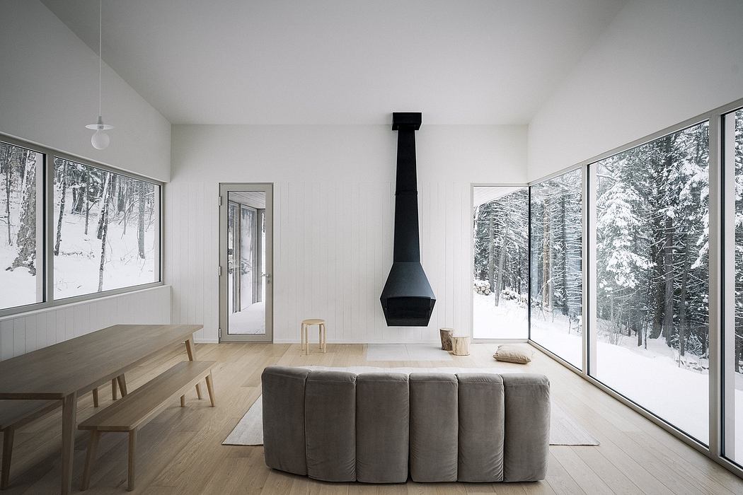 Minimalist interior with hanging fireplace and snowscape view.