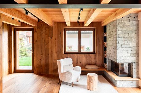 Cozy mountain retreat with rustic wood paneling, stone fireplace, and plush seating.