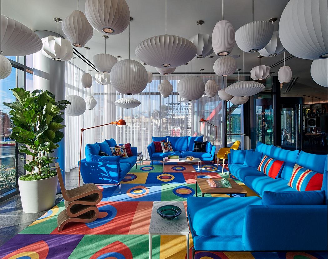 Modern lounge with colorful furniture and hanging white lamps.