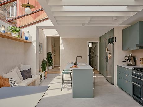 Modern kitchen with island, teal cabinets, and skylight.