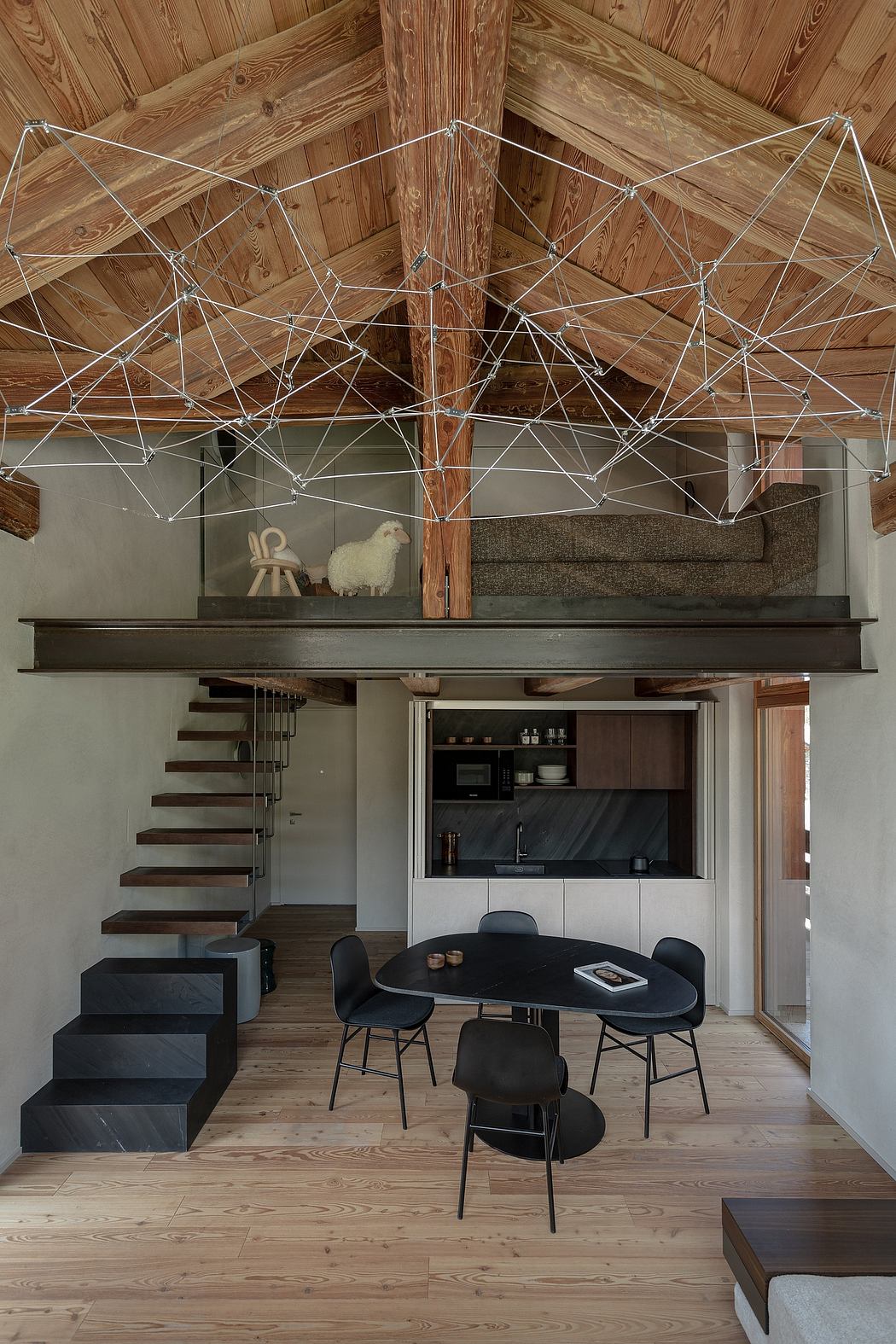 Contemporary loft space with exposed wooden beams and geometric hanging decor.