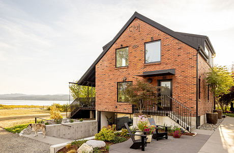 Contemporary brick home with balcony overlooking scenic landscape.