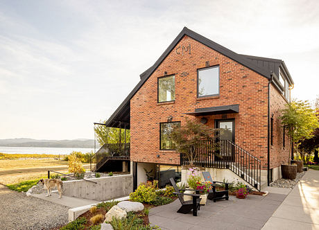 Contemporary brick home with balcony overlooking scenic landscape.