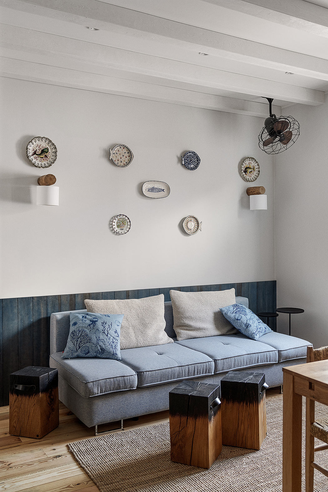 Cozy living space with decorative plates on wall and grey sofa.