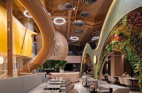 Vibrant, organic-inspired interior design with curved shapes, lighting, and greenery.