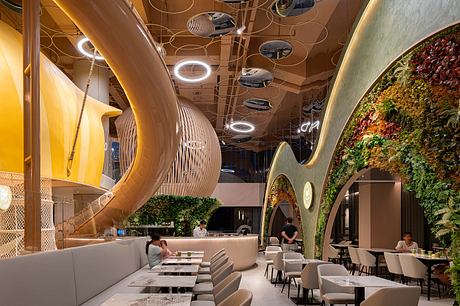 Vibrant, organic-inspired interior design with curved shapes, lighting, and greenery.