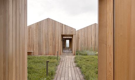 Wooden building exterior with central walkway and symmetrical design.