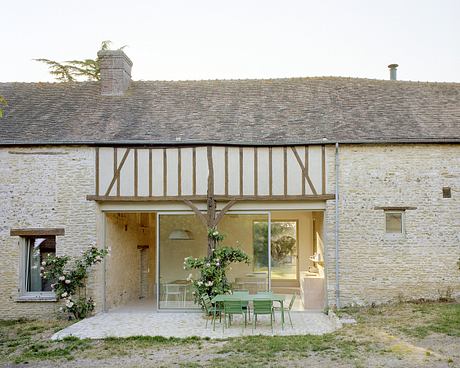 Traditional half-timbered house with modern glass extension.