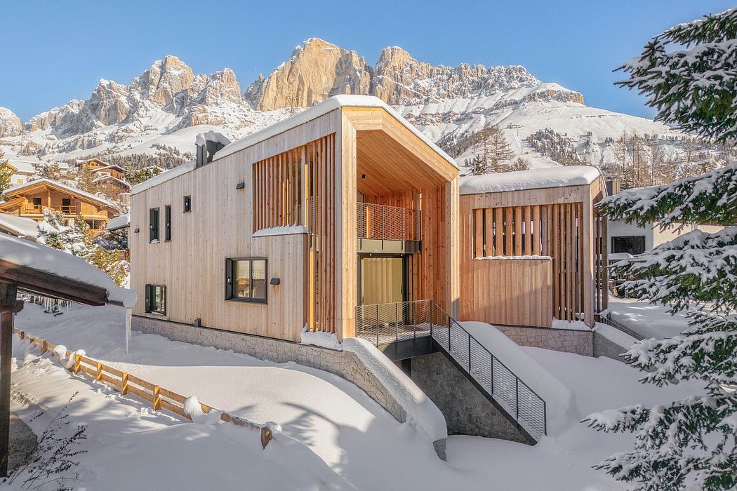 A modern wooden chalet surrounded by snowy mountains and pine trees, with a sleek architectural design.