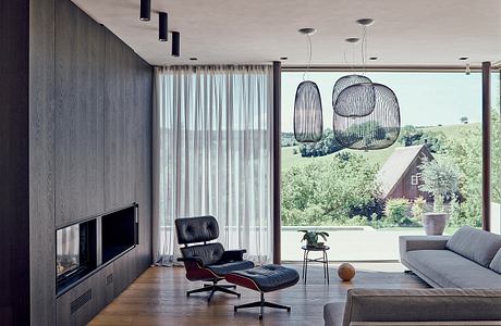 Contemporary living space with sleek furniture and oversized pendant lights.