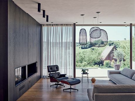 Contemporary living space with sleek furniture and oversized pendant lights.