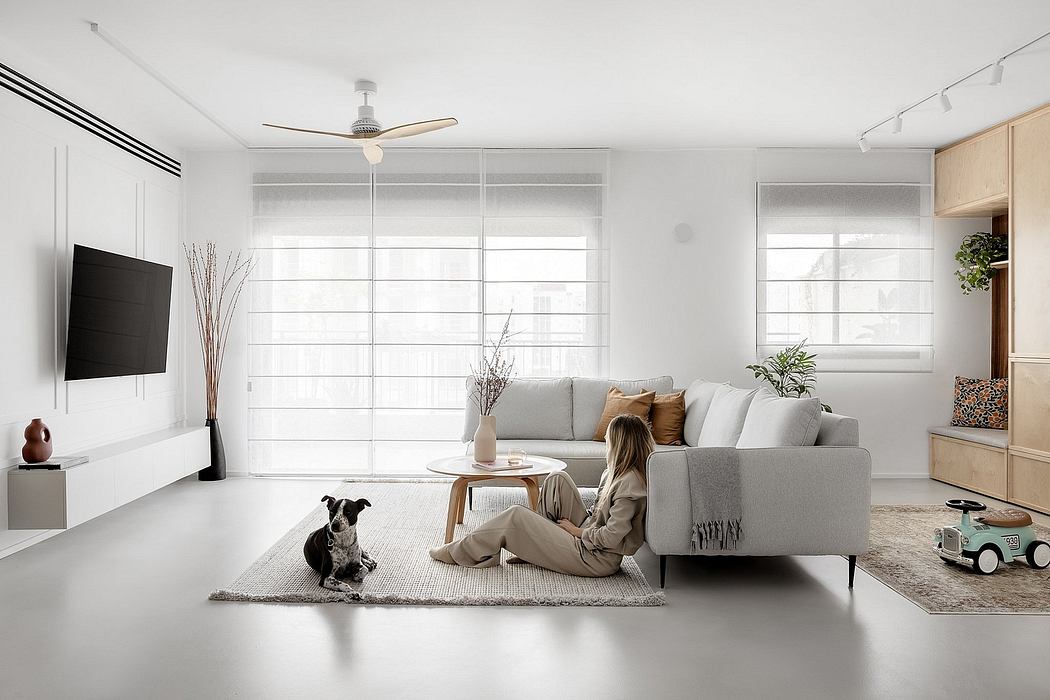 Minimalist living room with a person and dog, neutral tones, and clean design