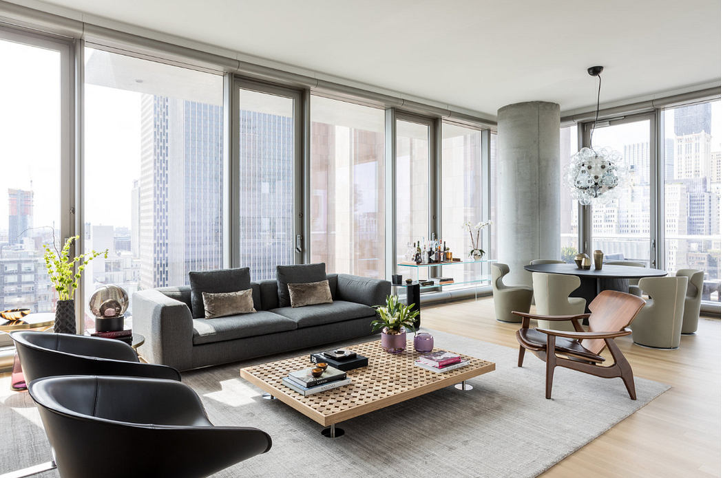 Sleek high-rise living room with large windows and city view.