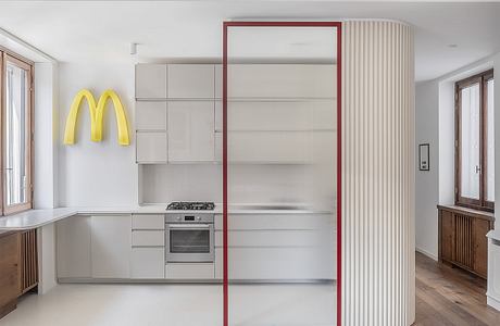 Modern kitchen interior with minimalist design and a McDonald's logo on the wall.