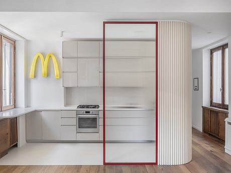 Modern kitchen interior with minimalist design and a McDonald's logo on the wall.