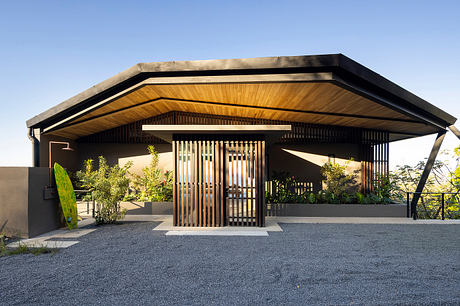 Modern house with slanted roof and wooden slat details.