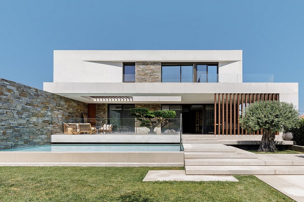Modern minimalist building with stone walls, glass facade, and private pool.