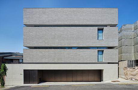 Minimalist urban building with horizontal lines and large windows.