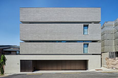 Minimalist urban building with horizontal lines and large windows.