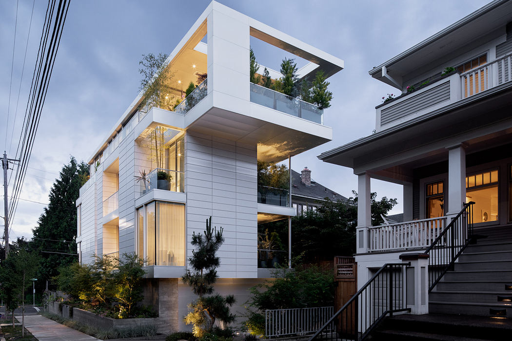 Modern architectural design with cantilevered balconies, glass walls, and outdoor lighting.
