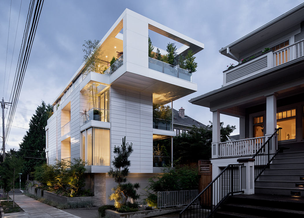 Modern architectural design with cantilevered balconies, glass walls, and outdoor lighting.