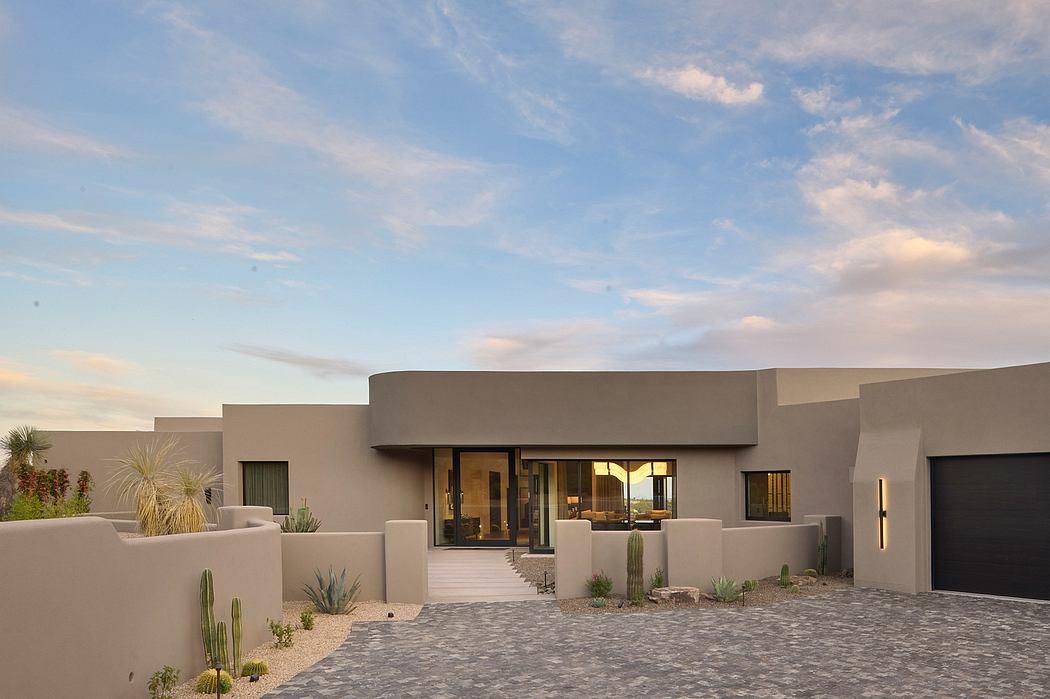 Contemporary desert-style home with clean lines, large windows, and landscaped desert plants.