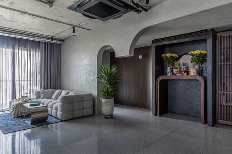 A modern, minimalist living space with gray tones, textured walls, and a built-in niche.