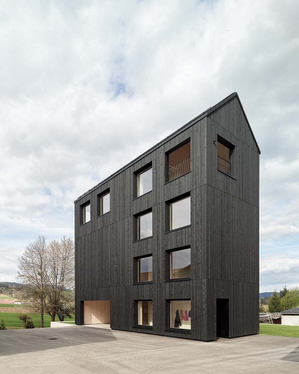 Striking modern building with clean lines, extensive windows, and a dark wooden exterior.